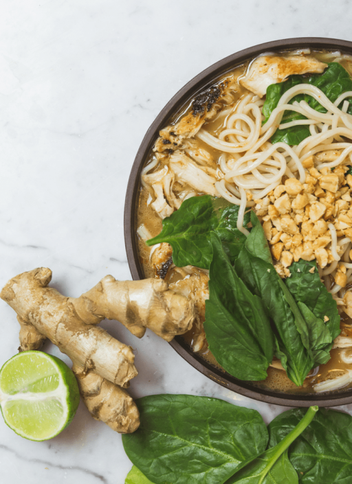 Ingwerknolle neben einer Schüssel Ramen