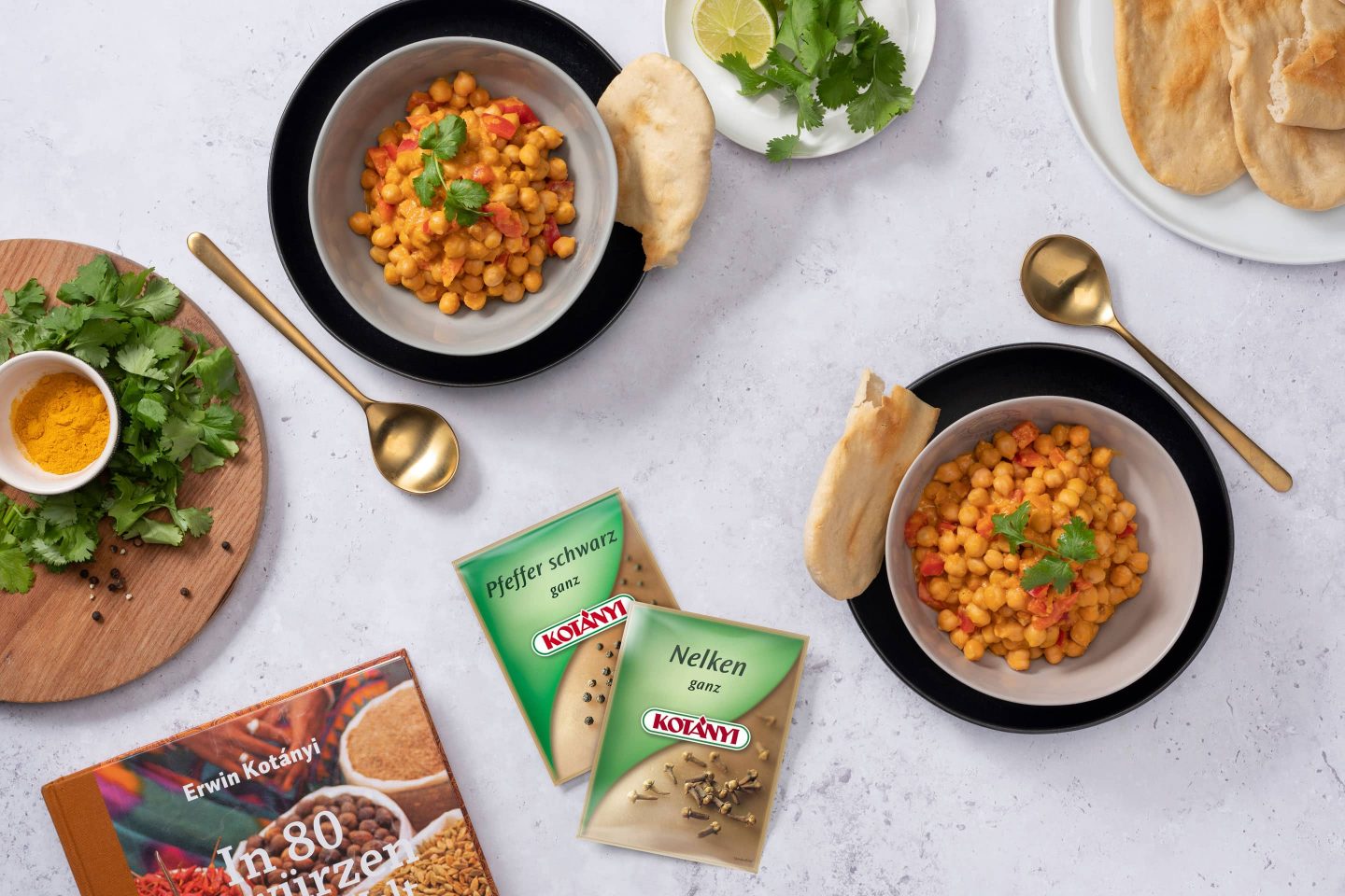 Slanutak u curry umaku s naanom uz vrećice crnog papra i cijelog klinčića.